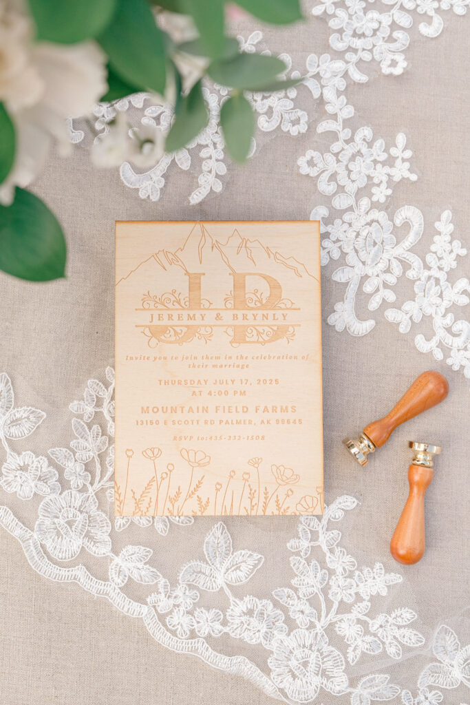 Flat lay of wedding details with lace dress and pastel florals, Mountain Field Farms Alaska wedding inspiration