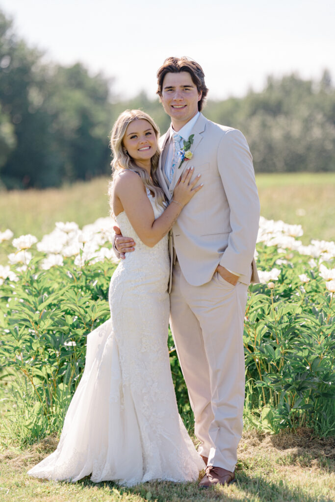 Bride and groom smiling in the fields at Mountain Field Farms wedding in Palmer, Alaska